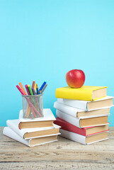 Books stacking. Books on wooden table and blue background. Back to school. Copy space for ad text.