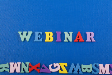 WEBINAR word on blue background composed from colorful abc alphabet block wooden letters, copy...
