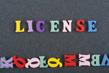 LICENSE word on black board background composed from colorful abc alphabet block wooden letters,...