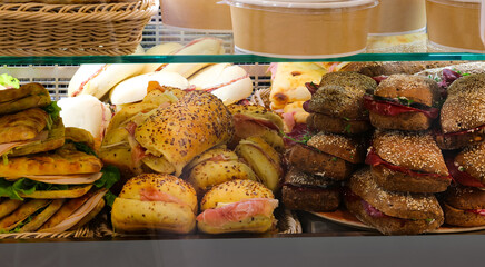 stuffed sandwiches with cold cuts and vegetables for sale at the bar counter