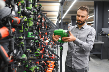 a buyer in a hardware store walks between with a power tool
