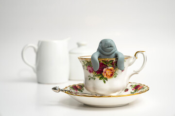 Teacup and saucer with manatee and milk and sugar