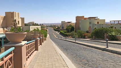 Long street in El Gouna in Egypt with typical local architecture during hot summer day