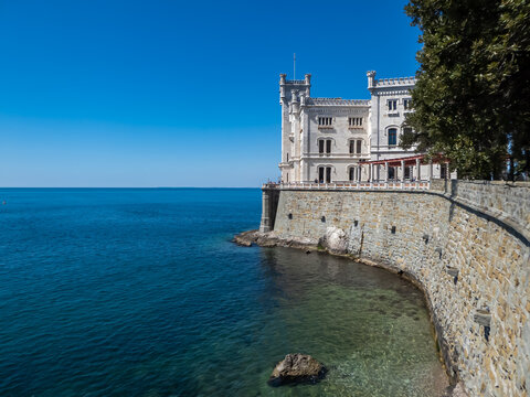 Scenic view of majestic historic white Miramare castle in Trieste in Friuli-Venezia Giulia, Italy, Europe. Blue sky in tranquil atmosphere at Adriatic Mediterranean sea in summer. Sightseeing