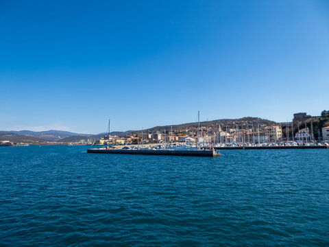Scenic view from a ferry of the port of Trieste from in Friuli-Venezia Giulia, Italy, Europe. Blue sky in tranquil atmosphere at Adriatic Mediterranean sea in summer. Boat tour along the coastline