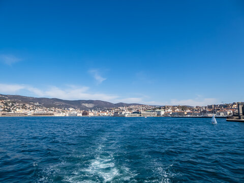 Scenic view from a ferry of the port of Trieste from in Friuli-Venezia Giulia, Italy, Europe. Blue sky in tranquil atmosphere at Adriatic Mediterranean sea in summer. Boat tour along the coastline