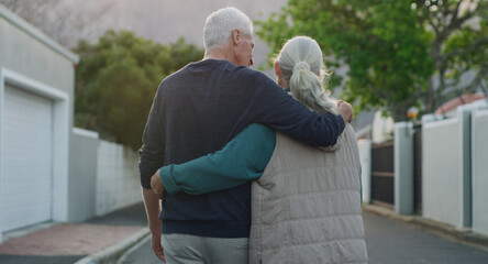 Senior couple, walk and hug outdoor in city, road and driveway of house for love, peace and support. Elderly people, freedom and retirement together in nature, environment or urban with back view
