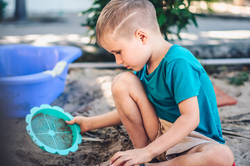 Child playing in sandbox. Happy childhood freedom creativity development, tactile Nature sensations