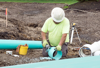 Worker Trimming PVC Drainage Pipe Section