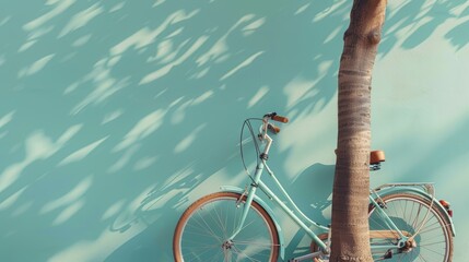 A blue vintage bicycle leaning against a blue wall with a palm tree next to it. - obrazy, fototapety, plakaty