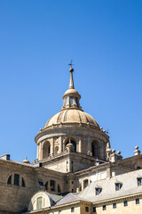 Fototapeta na wymiar The sculptural details and the emblematic dome of the Monastery of El Escorial with its roofs