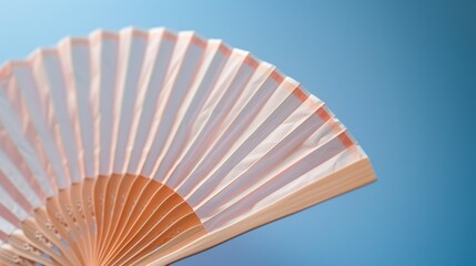 A peach-colored fan is held open against a blue background.