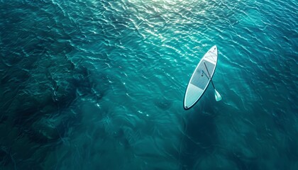 An aerial view of a stand-up paddleboard floating in the ocean. - obrazy, fototapety, plakaty