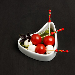 Mini mzzarella and cherry tomatoes with olive oil in a bowl