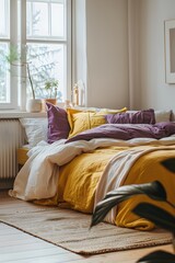 A bedroom with white walls, yellow bed linen and purple pillows, carpet on the floor, a window to one side of the room, natural light, wooden flooring, a minimalistic style