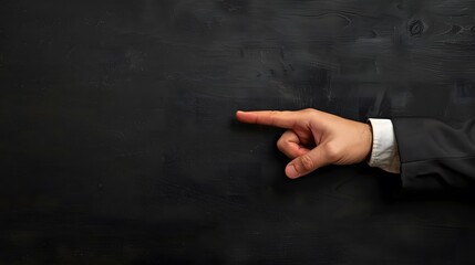 Businessman's hand pointing on black wooden table. 