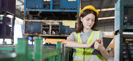 Female warehouse worker wearing safety uniform working with digital tablet and inspecting quality...