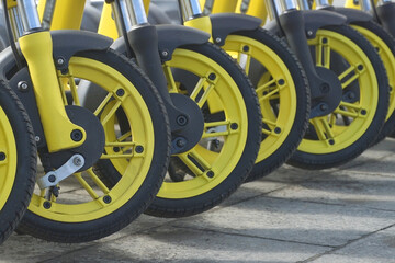 A row of front wheels of scooters. Movement concept.