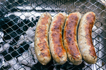 Sausages are fried on a disposable grill. Smoking sausages.
