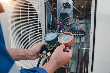 Technician is checking air conditioner,measuring equipment for filling air conditioners.