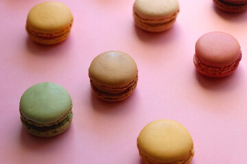 Fototapeta na wymiar Colorful macarons on pink background. Selective focus.