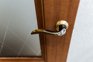 Close up of a woodstained door handle on a hardwood door