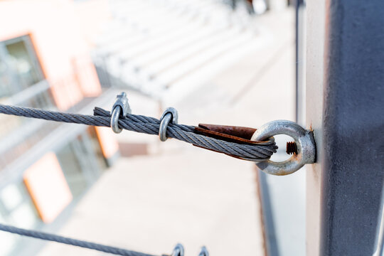 Close up of metal pole with attached rope, part of security fencing