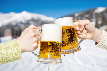 Celebrating with glasses of beer in a ski resort.