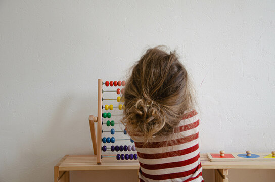 Enfant qui compte sur un boulier en bois multicolore 