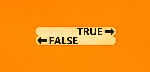 True or false symbol. Concept word True or False on beautiful wooden stick. Beautiful orange table...