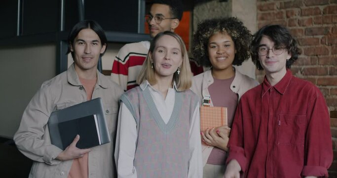 Slow motion portrait of business people diverse group standing in creative office smiling looking at camera. Successful teamwork and job concept.
