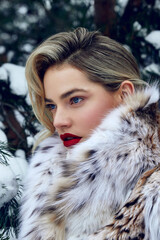 Beautiful young woman with perfect skin. A woman in a lynx fur coat against the backdrop of a snowy forest. Luxurious furs, expensive luxury clothes. Clothes advertising. Skin care cosmetics.