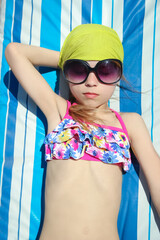 Happy child in glasses sunbathing on the seashore background - 793144756