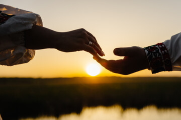 Couple holding hands over water