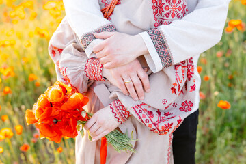 Man and woman holding each other in field of flowers
