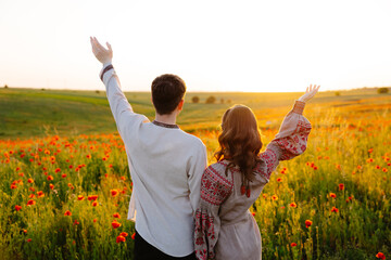Man and woman standing in a field of flowers - obrazy, fototapety, plakaty