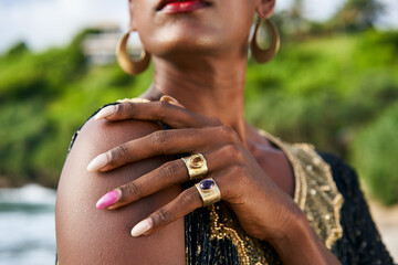 Trans sexual ethnic fashion model with brass jewelry accessories in elegant posture. Epatage gay...