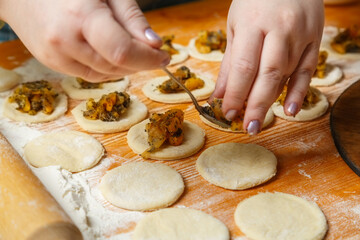 Jewish women's hands lay out the poppy seed filling for sweet gomentash for the holiday of Purim