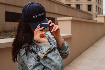 Young woman wearing vintage denim jacket and blue cap with text New York, Street style urban cloth