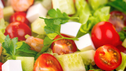 Salad in a Greek shrimp salad. A close-up salad of fresh vegetables, a plate of fresh salad with vegetables and herbs. The concept of a delicious and healthy dish. Greek salad with juicy tomatoes.