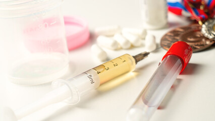 A syringe with a prohibited medication against the background of athlete's medals and awards