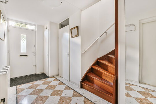 Bright hallway interior with staircase and tiled floor