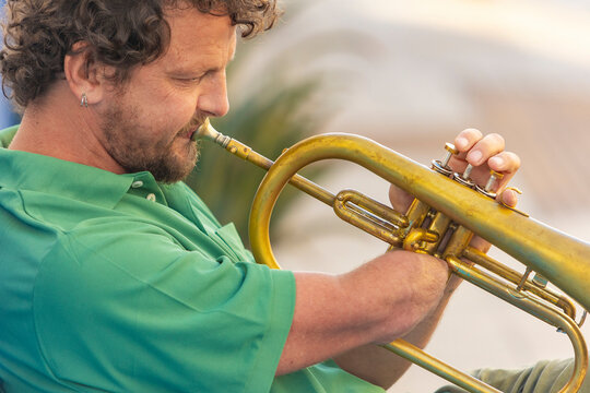 Passionate one-armed trumpet player performs outdoors
