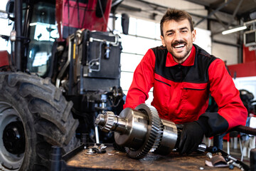 Experienced mechanic repairing and servicing transmission gears for tractor agricultural machine.