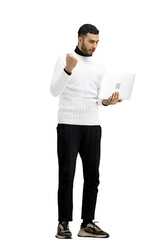 A man, full-length, on a white background, uses a laptop