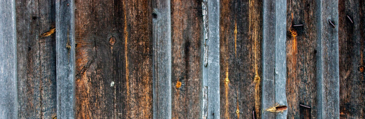 Fragment of a wall made of old natural wood boards. The boards create a pattern of natural pine...