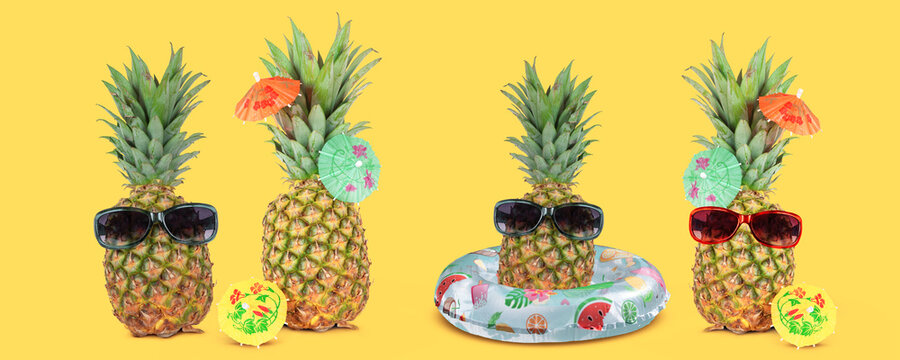 Tropical summer vacation concept with funny stylish pineapples isolated on yellow background.