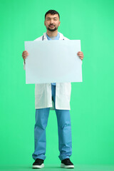 The doctor, in full height, on a green background, shows a white sheet
