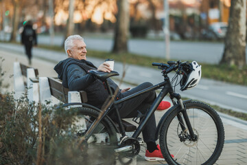Man Enjoying a Coffee While Resting on a Bench Next to Bike