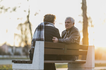 Senior Man and Woman Sitting on a Bench and Talking